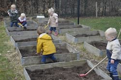 Kinderen helpen in de moestuintjes