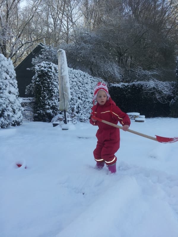 Kinderen helpen mee met sneeuwschuiven