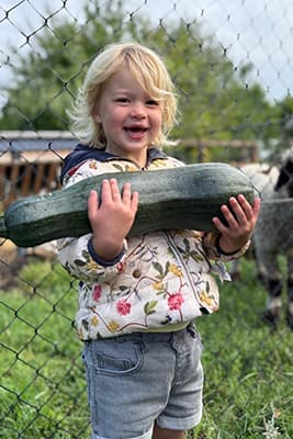 Kinderen met groentes uit de moestuin